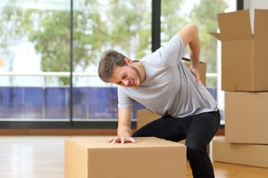 Man moving boxes suffering back ache